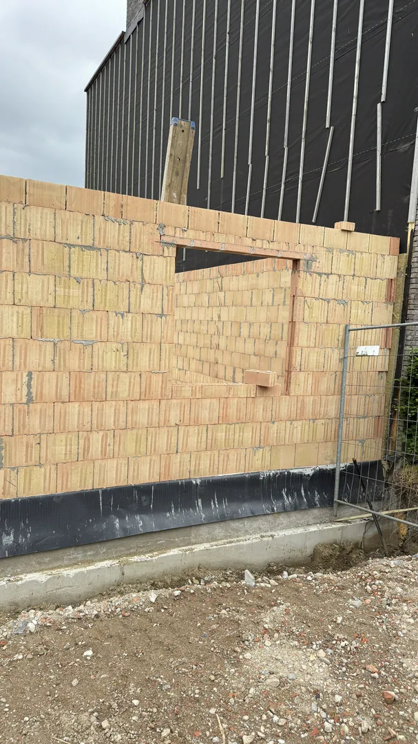 Ściany i stropy: murowana ściana z pustaków z otworem okiennym nad izolacją fundamentów