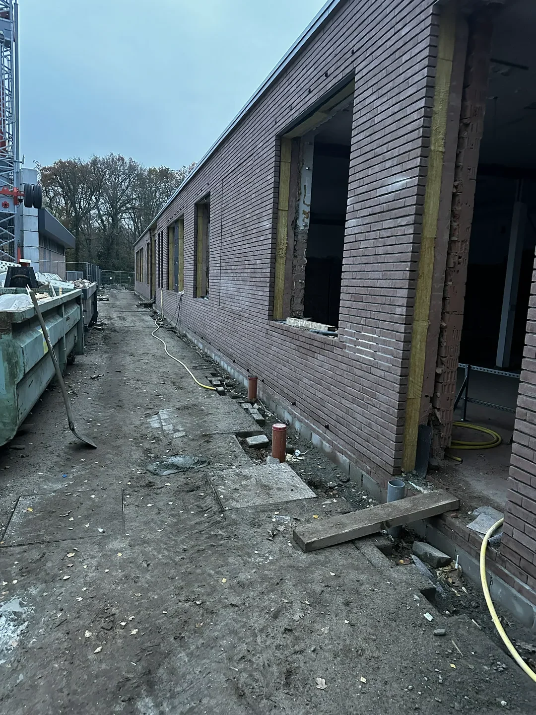 Ściany i stropy domu jednorodzinnego w stanie surowym z otworami okiennymi i przygotowanym terenem budowy