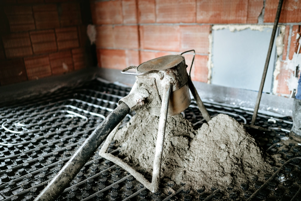 Pompa do wylewek betonowych na siatce rur ogrzewania podłogowego w przygotowywanym domu