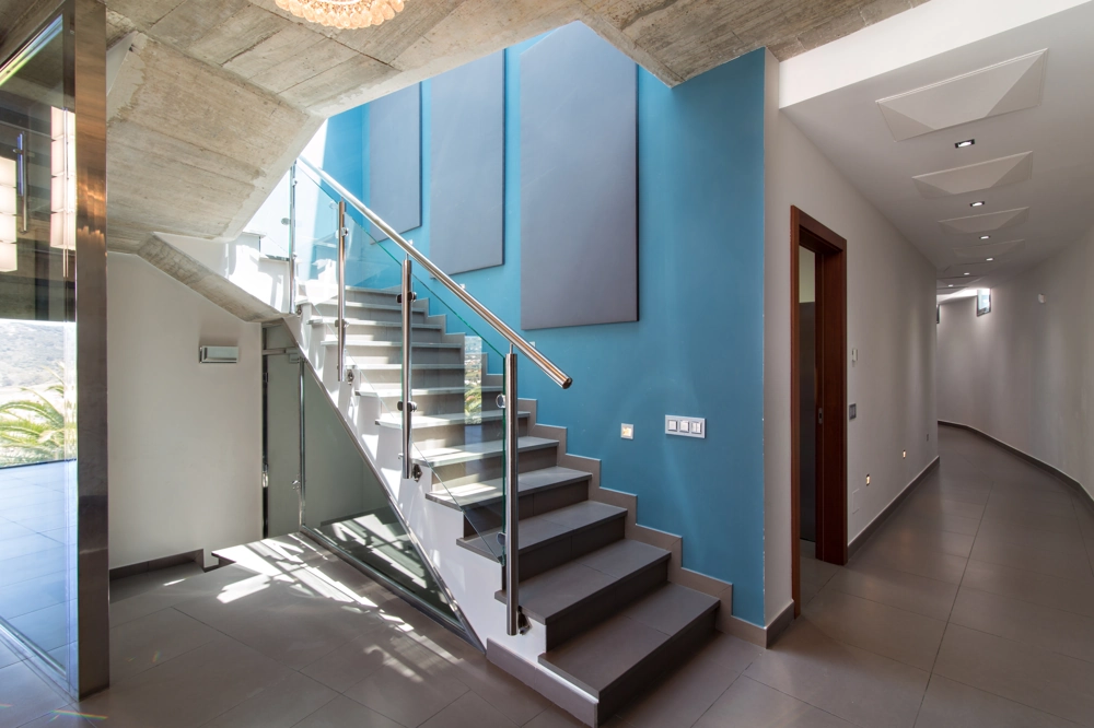 Schody betonowe ze szklaną balustradą w nowoczesnym wnętrzu